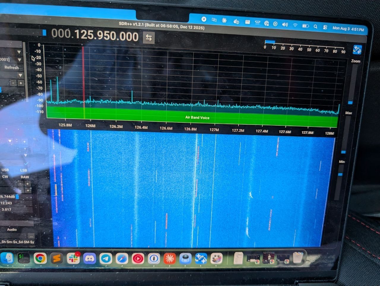 SDR++ on a MacBook screen showing a blue waterfall display with several bright vertical lines where airport frequencies are active